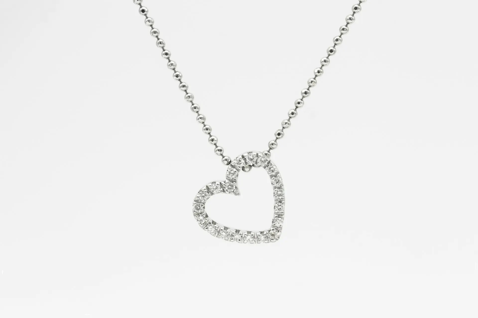 silver heart pendant necklace on white background
